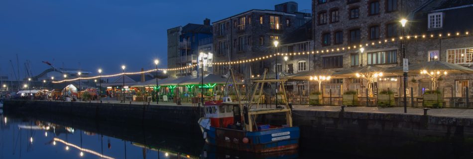 Barbican_waterfront_in_Plymouth_at_night_with_illuminated_harbour_boats_and_historic_buildings_reflected_in_water