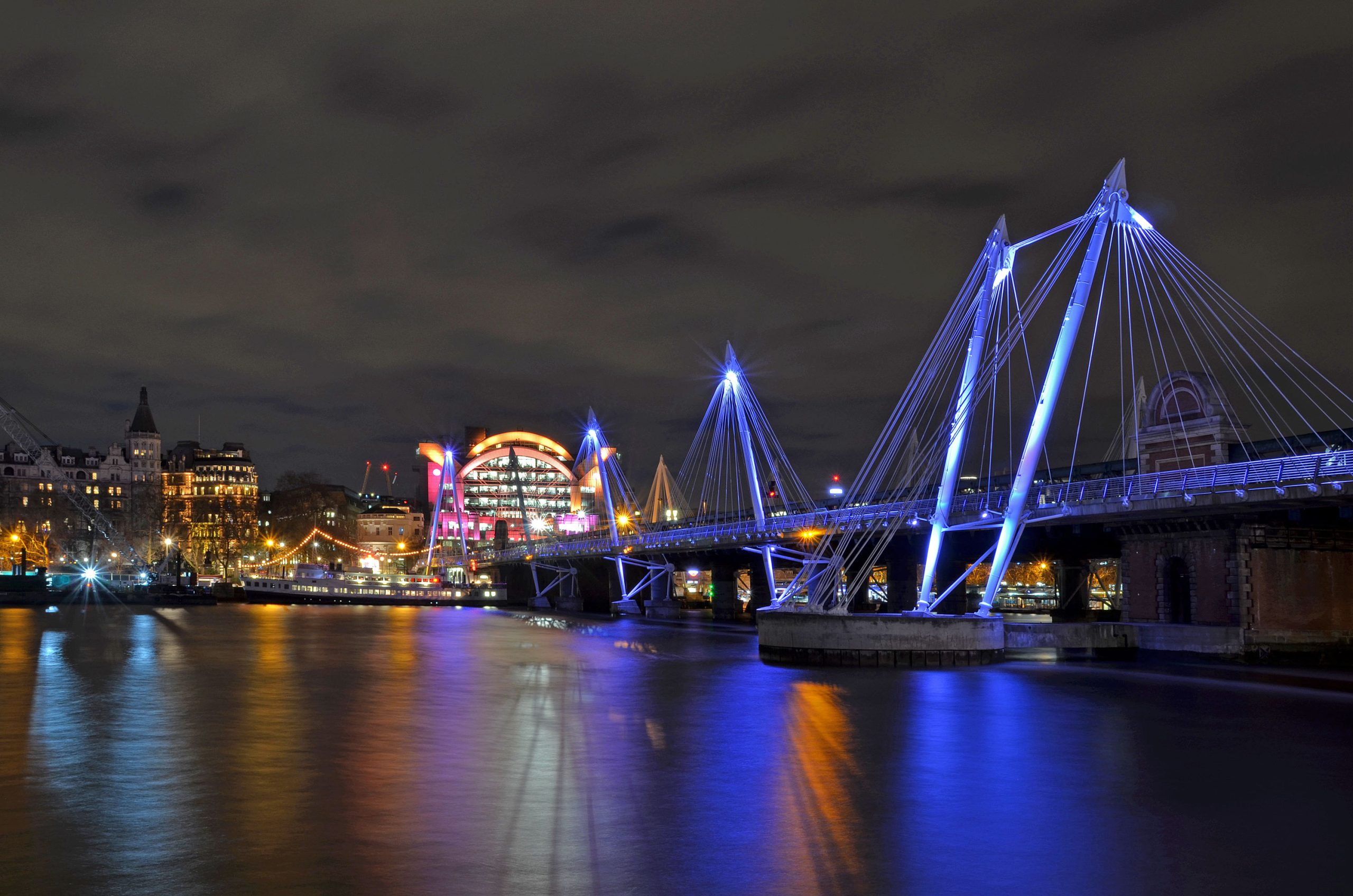 Jubilee_Footbridge_near_Charing_Cross_in_London_with_night-time_reflections_in_Thames