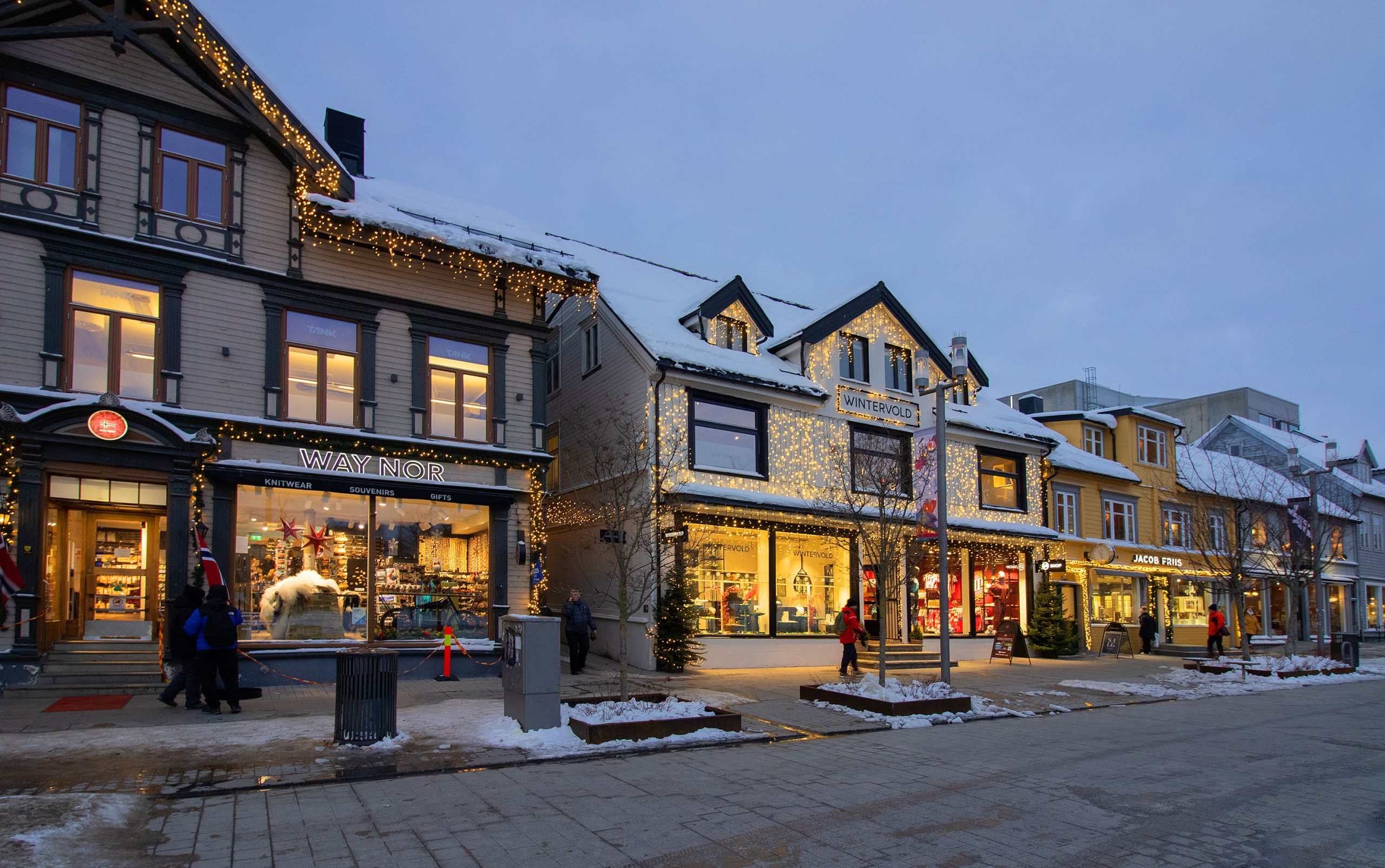 Snow_covered_pedestrian_street_Storgata_in_Tromsø_with_shops_and_cafés_illuminated_by_Christmas_lights