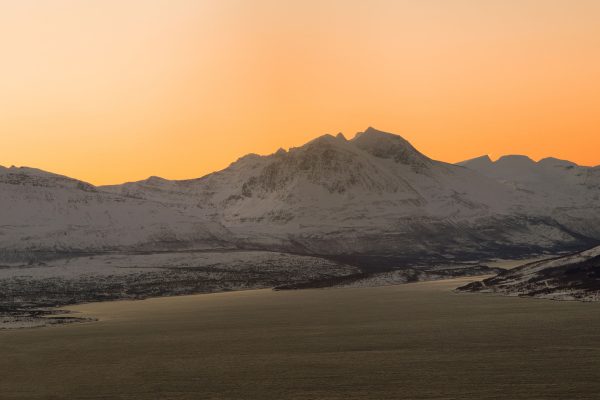 sunset_casting_warm_colors_over_the_Lyngen_Alps_with_rugged_peaks_in_northern_Norway