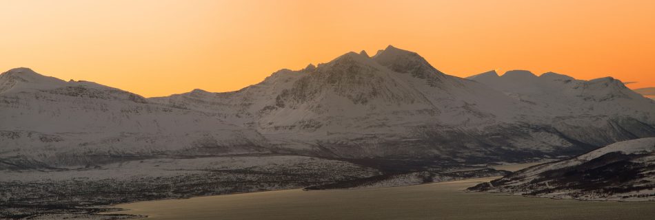 sunset_casting_warm_colors_over_the_Lyngen_Alps_with_rugged_peaks_in_northern_Norway