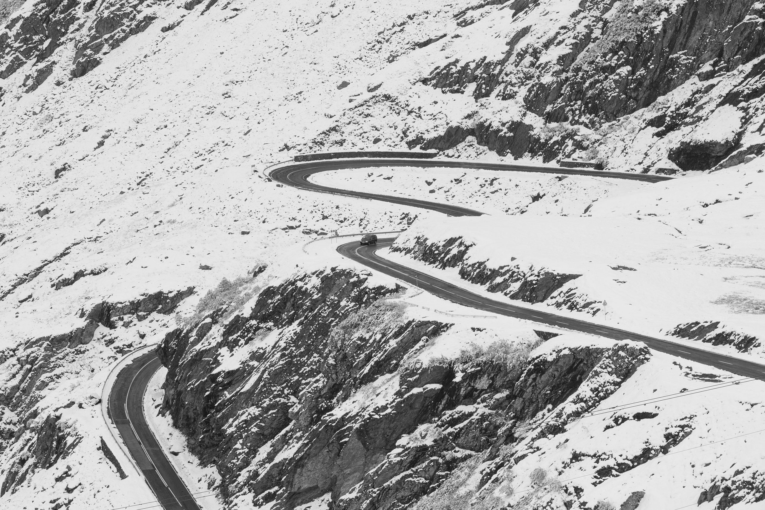 Transfăgărășan_Highway_winding_through_snow_covered_mountains_in_Romania
