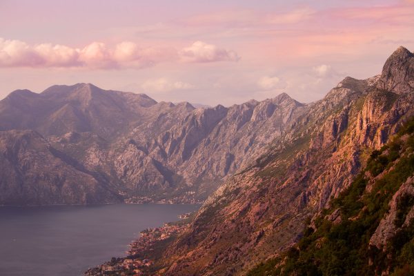 Mountain_coastline_with_dramatic_peaks-and_calm_bay_at_sunset