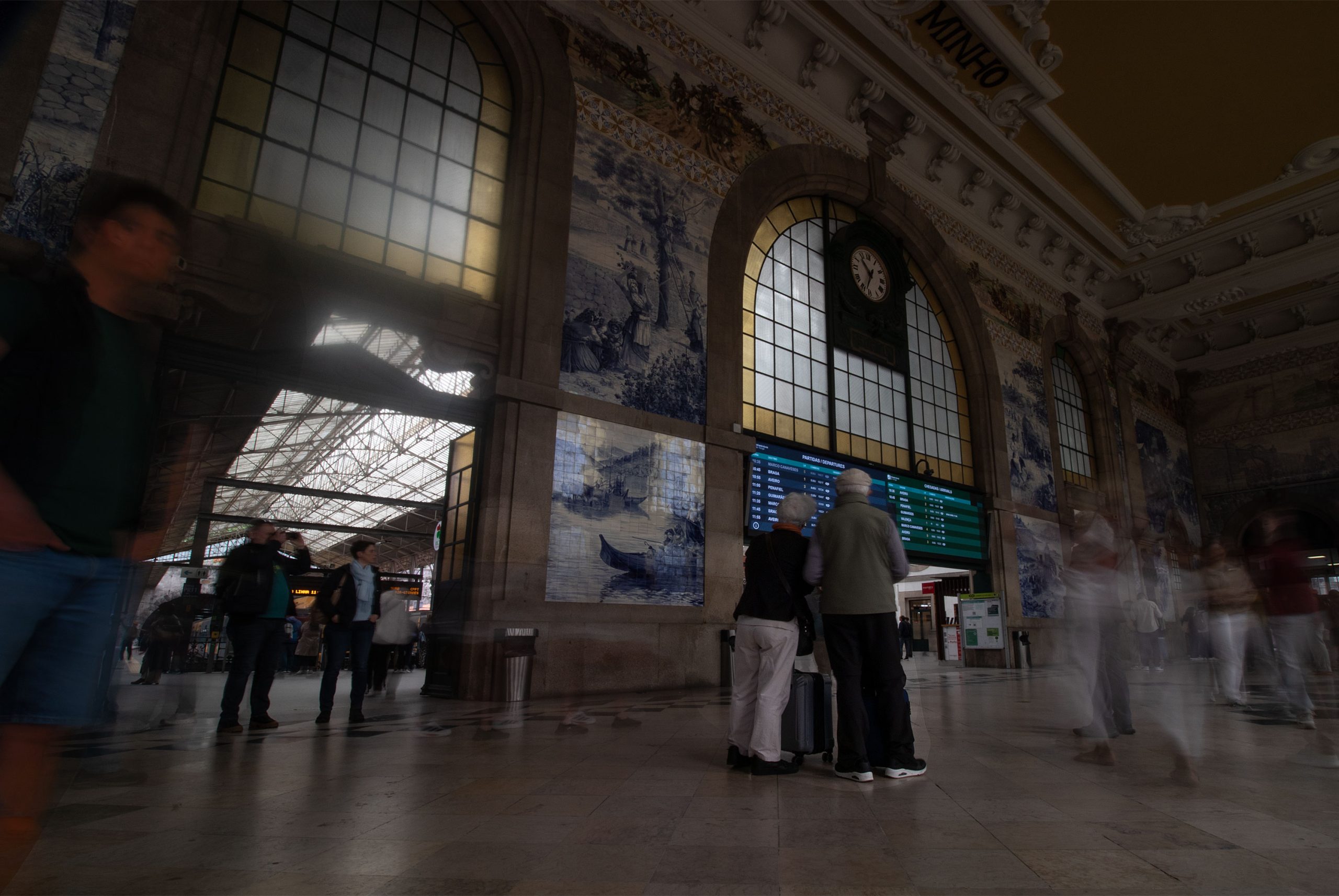 Travelers_inside_São_Bento_Railway_Station_in_Porto_with_historic_azulejo_tile_murals