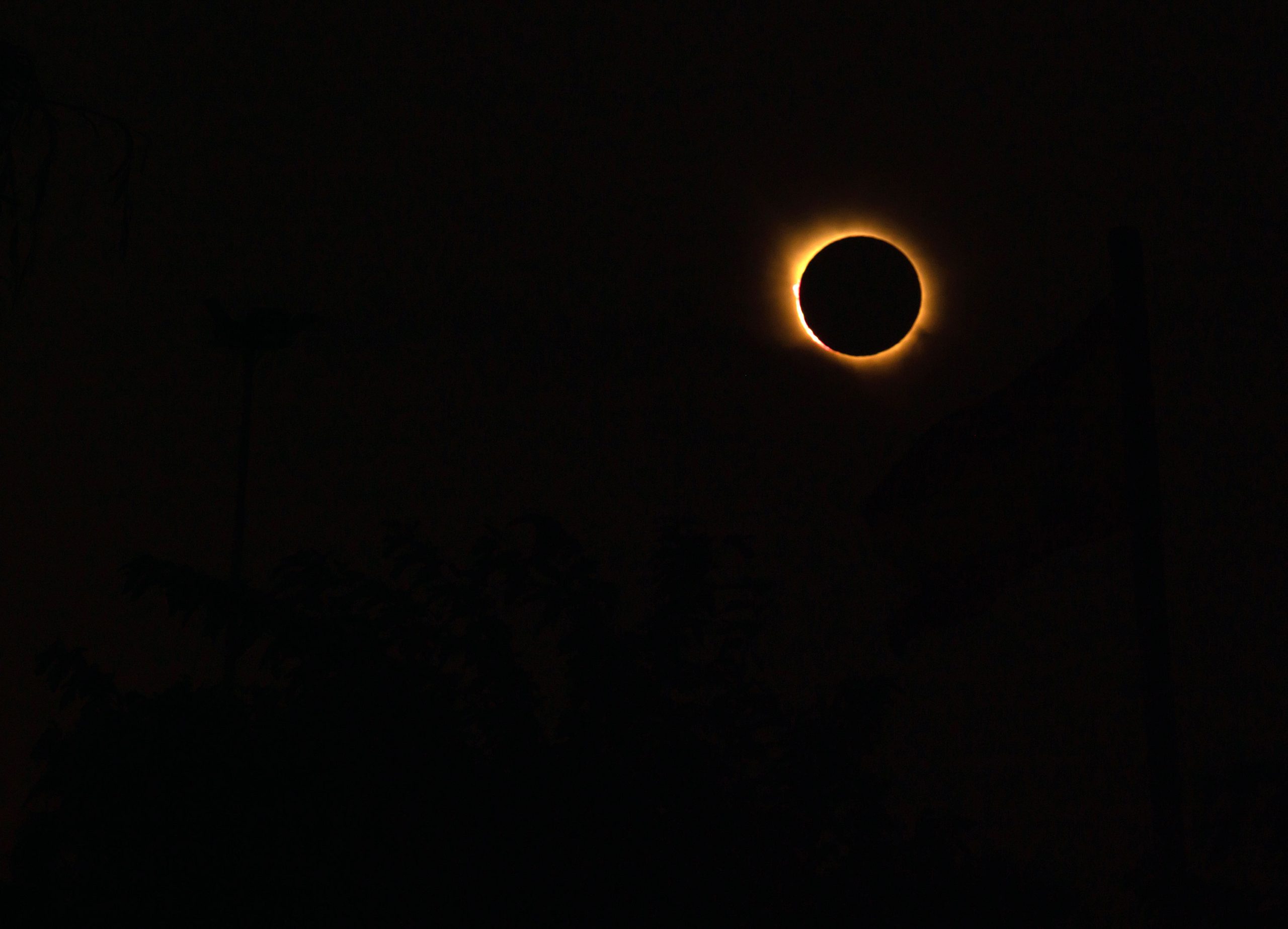 total_solar_eclipse_showing_a_bright_diamond_ring_effect against a dark sky.